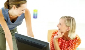 Two Young Women in Front of the Computer Talking